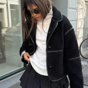 Svart teddyjacka - Snygg svart teddyjacka med knappar och en croppad passform. Perfekt för att hålla sig varm och stilren under kyligare dagar. Jackan har långa ärmar och en mjuk, fluffig yta som ger en trendig look. Från Nelly knappt använd 