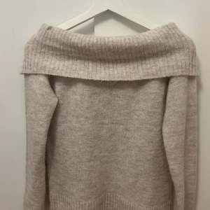 Beige stickad tröja från Gina Tricot - Säljer en beige off-shoulder stickad topp från Gina tricot. Har använt den ett par gånger men den är nästan som ny. Jag har dock tröttnat på den så jag har inte använt den på ett tag🩷