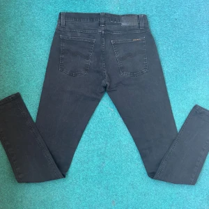 Svarta jeans från Nudie Jeans - Snygga svarta jeans från Nudie Jeans med en tight passform. De har klassiska fem fickor och en dragkedja. Perfekta för en stilren look.