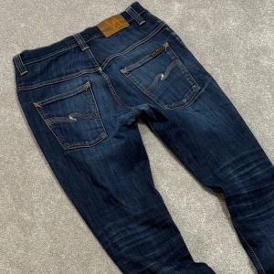 Nudie Jeans - Tja! Säljer dessa feta blå Nudie jeans med riktigt schysst tvätt! Jeansen är utav modellen ”Thin Finn” och har en slimfit passform. Fint skick, lite sönder i ena fickan men märks knappt av. Size 32/34 med passar 32/32. Skriv vid funderingar!