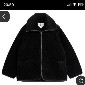 Svart teddyjacka med dragkedja - Mysig svart teddyjacka från H&M med dragkedja framtill. Jackan har en klassisk krage och två stora fickor. Perfekt för kyliga dagar när du vill hålla dig varm och stilren.