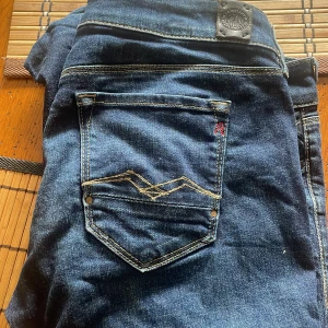 Blå jeans från Replay - Snygga blå jeans från Replay med klassisk femficksdesign och coola detaljer som stjärnformade nitar. Perfekta för en stilren look med en tight passform. Märket Replay är känt för sin kvalitet och stil. Finns det fler frågor är det bara att hugga till!🙌🙌MVH Maurice 