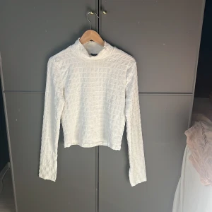 Vit långärmad topp - Säljer en stilren vit topp med ribbad struktur och långa ärmar. Perfekt för en minimalistisk look. Toppen har en enkel design som gör den lätt att matcha med olika outfits.💕