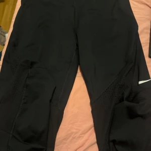 Nike leggings - Snygga nike leggings med genomskinliga ränder vid knärna. Har lite tecken på användning men inga dekter därav priset!