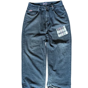 Mörkblå Baggy Jeans - (F4k3) Jnco-jeans med lappar på höger bakficka och framtill.  Storlek: XL  Skick: Överlag i mycket bra skick men har rejält med "heelbite" (slitning vid hälen). Det bidrar dock till estetiken.  Notera: Materialet är väldigt mjukt och bekvämt, men förvänta dig inte denim av hög kvalitet.  