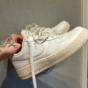 Nike Air Force sneakers - Säljer ett par klassiska vita Nike Air Force sneakers. De har en stilren design med snörning och rund tå. Perfekta för en casual look. Storlek 39. Sparsamt använda. Kommer från djur & rökfritt hem. 