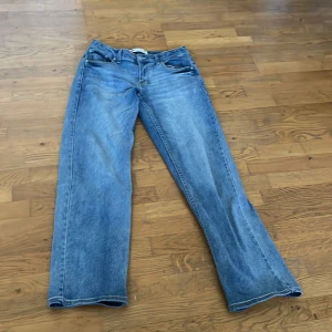 Blå jeans från Levi's - Säljer ett par klassiska blå jeans från Levi's med en loose tapered passform. De har en traditionell femficksdesign och en bekväm midwaist. Perfekta för en avslappnad stil.