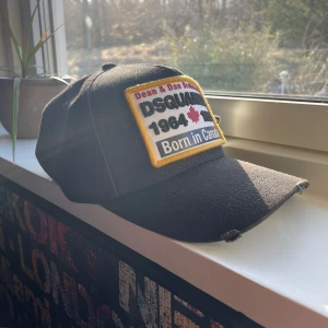 Svart keps från Dsquared2 - Snygg svart keps från Dsquared2 med broderad patch framtill och texten 'Family Business' baktill. Perfekt för en casual look. Säljer då den inte va min stil direkt. 