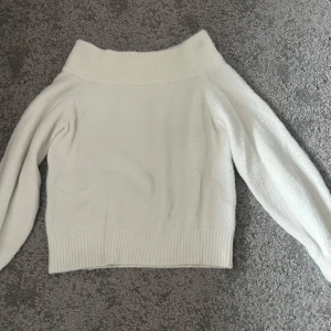 Vit stickad off shoulder tröja XS - Säljer en mysig vit stickad tröja med off shoulder. Tröjan har långa ärmar och ribbade kanter vid ärmslut och nederkant. Perfekt för kyliga dagar! Från h&m i storlek xs