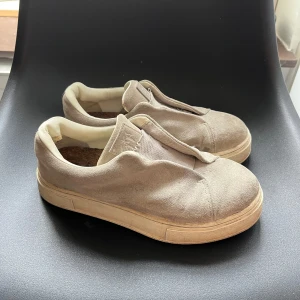 Gråa sneakers från Eytys - Säljer ett par stilrena beige sneakers från Eytys. Skorna har en rund tå och är tillverkade i mocka med en bekväm plattformssula. 