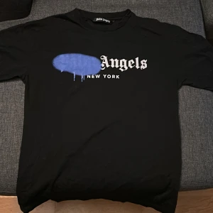 Svart t-shirt från Palm Angels - Snygg svart t-shirt från Palm Angels med tryck i vitt och blått framtill. 