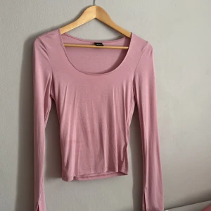 Rosa långärmad topp från Gina Tricot - Säljer en söt rosa långärmad topp från Gina Tricot. Toppen har en rund halsringning och är gjord i ett mjukt material som känns skönt mot huden. Perfekt för en avslappnad stil eller att klä upp med accessoarer. 💖