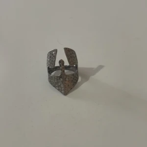 Unik silverfärgad ring - Säljer en unik och modern ring i silverfärg med en intressant geometrisk design. Ringen har en perforerad yta som ger den en cool och edgy look. Perfekt för att ge din outfit en extra touch av stil.