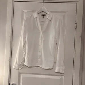 Vit skjorta med knappar - Elegant vit skjorta med klassisk krage och knappar framtill. Perfekt för en stilren look. Långärmad design som passar till många tillfällen.💗 Storlek S. 70kr
