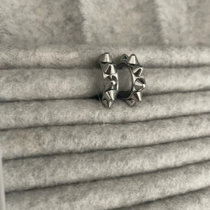 Silvriga örhängen med nitar från Edblad - Snygga silvriga örhängen från Edblad med coola nitar runt om. Perfekta för att ge en edgy touch till din stil. De är små och smidiga att bära, vilket gör dem till ett utmärkt val för både vardag och speciella tillfällen.