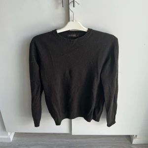 Svart stickad tröja Oscar Jacobson - Klassisk svart stickad tröja från Oscar Jacobson med rund halsringning och ribbade muddar. Perfekt för lager-på-lager och enkel att matcha med jeans eller chinos. Mjuk och skön känsla, passar dig som gillar stilren och tidlös look. Köparen står för frakten.