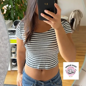 Randig croppad topp i svart och vitt - Säljer en croppad topp med svarta och vita ränder. T-shirten har korta ärmar, rund halsringning och är ribbad i materialet. Perfekt för dig som gillar en enkel men snygg stil med lite edge.