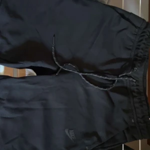 Svarta nike tech shorts. - Säljer ett par svarta nike tech shorts, storlek M men passar även S. Helt nya.