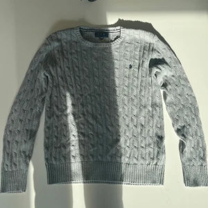 Grå kabelstickad tröja Polo Ralph Lauren - säljer en grå kabelstickad tröja från Ralph lauren! Den är knappt använd, perfekt skick. Pris kan diskuteras vid snabb affär. Hör av er vid minsta fråga!!