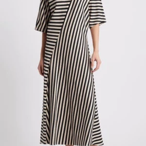 Randig långklänning från COS XS - Snygg långklänning från COS i svart och beige med breda ränder i olika riktningar. Klänningen har rund hals, halvkort ärm och en loose passform som ger en cool och avslappnad vibe. Perfekt för dig som gillar grafiska mönster och minimalistisk stil.