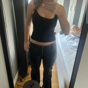 Svarta byxor i skinnimitation - Säljer ett par svarta skinnbyxor med låg midja och dragkedja framtill. Dem är endast använda fåtal gånger så i dem är i fint skick. Dem är från Gina Young i storlek 164 och passar mig bra som vanligtvis bär xs/s men kan möjligtvis passa större då dem är lite stretchiga.💞