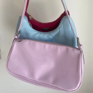 Handväska trio - Tre handväskor varav de rosa är i gott skick medan den blåa är lite smutsig. Går eventuellt att tvätta bort, har inte provat men den åker med i paketet för den som vill prova. 