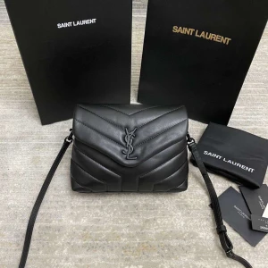 Svart quiltad axelväska från Saint Laurent - Säljer en svart quiltad axelväska från Saint Laurent med ikoniskt YSL-emblem framtill. Väskan är tillverkad i mjukt skinn och har justerbar axelrem. Invändigt finns flera fack och dragkedja för smart organisering. Perfekt för dig som vill ha en stilren och lyxig look.