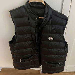 Svart dunväst från Moncler - Snygg svart dunväst från Moncler med klassisk logga på bröstet. Helt äkta. Nypris 6000 kronor. Skick 9/10. Mitt pris 2000