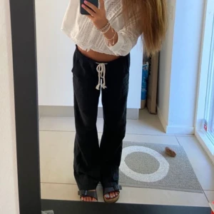 svarta roxy linnebyxor  - Intressekoll på mina svarta linnebyxor från roxy. Byxorna har raka, vida ben och vit knytning vid midjan. Mycket bra skick utan några synbara defekter, förutom att benen är uppsprättade längst ner för att passa min längd (168). 