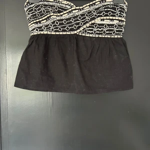 Svart tubtopp - Svart tubtopp med pärlmönster från Zara, köpt i Spanien för två år sen och säljs inte längre. Har några få defekter på det mönstrade området (se bild 4&5)💕