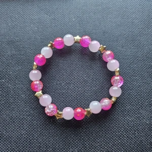 Rosa pärlarmband med stjärndetaljer - Supergulligt armband med pärlor i olika nyanser av rosa och glittriga detaljer. Mellan pärlorna sitter små guldiga stjärnor som ger extra wow-känsla. 