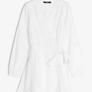 Vit omlottklänning från Bik Bok - Superfin vit omlottklänning från Bik Bok med långa ärmar och knyt i midjan. Klänningen har v-ringning och är i en kort modell, perfekt för sommarens alla tillfällen. Enkel och stilren design som är lätt att matcha.🩵