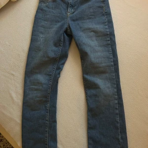 Blå jeans från Vero Moda - Snygga blå jeans från Vero Moda med klassisk femficksdesign och raka ben. Jeansen har hög midja och är gjorda i mjukt denimtyg med lite stretch för extra komfort. Perfekta till sneakers eller boots för en chill look.