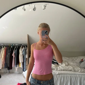 Rosa ribbad linnetopp från Monki - Säljer en ljusrosa croppad linnetopp från Monki i storlek XS. Toppen har snygga axelband och är ribbad i materialet. Perfekt att matcha med jeans, shorts eller kjol!🩷