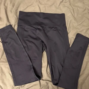 Träningsbyxor  - Snygga blåa leggings med  hög midja från Drop of Mindfulness. De är tillverkade i ett stretchigt syntetmaterial som sitter tight och bekvämt. Perfekta för träning eller chill, med diskret logga framtill på linningen. .