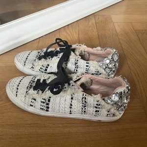 Zara sneakers med pärlor och fransar - Så coola och unika sneakers från Zara i vit och svart tweed med fransiga detaljer och stora glittriga pärlor på hälen. Skorna har svarta snören och en rund tå💌💌💌💌