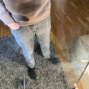 Levi's 501 grå jeans straight fit - Säljer ett par klassiska Levi's 501 jeans i grå tvätt med straight fit. Jeansen har fem fickor, knappgylf och den ikoniska läderpatchen bak i midjan. Perfekt för dig som gillar en tidlös och chill stil. Passar både till hoodie och t-shirt.