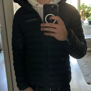 Peak Performance blå dunjacka  - Säljer en snygg blå dunjacka från Peak Performance. Använd några månader så den är nästan nyskick förutom ett hål i fickan (sista bilden). Nypris 2900 kr. Jag är 183 och den är på gränsen till kort.