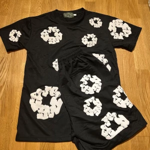 Denim tears - Helt nytt denim tears med unikt vitt grafiskt tryck över hela plagget. Modellen har elastisk midja med snörning och är tillverkad i mjuk bomull som känns skön mot huden. Perfekt för dig som gillar streetwear och vill sticka ut.