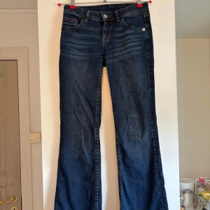 Bootcut jeans med broderad ficka - Snygga mörkblå bootcut jeans med låg midja. använda men i fint skick. 