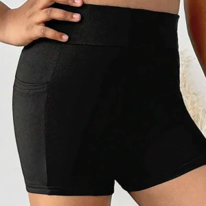 Träningsshorts - Svarta, tighta träningsshorts med kort benlängd och bred linning. Perfekta för träning eller chill, med enkel design och diskreta sömmar. Stretchigt material som sitter skönt och följer kroppen. Storlek XXS, XS. Aldrig använda.
