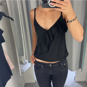svart topp med volang - säljer denna söta topp med en volang över bröstet, det är toppen på andra bilden fast svart som ni ser på bild 1 när jag har på mig den💕