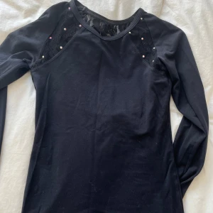 Konståknings tröja  - Svart konståknings tröja från bolero. Nypris runt 900kr. Diamanterna på armen är nästan helt borta men resterande diamanter sitter alla kvar. Används en del men är fortfarande i fint skick (förutom armen med diamanterna)