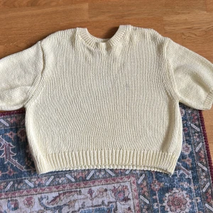 Ljusgul stickad tröja  - Superfin ljusgul stickad tröja från Gina Tricot i storlek S. Tröjan har rund hals, ribbade muddar och korta ärmar. Perfekt för dig som gillar en enkel och clean look med lite oversized känsla. Materialet är mjukt och skönt, passar både till jeans och kjol.