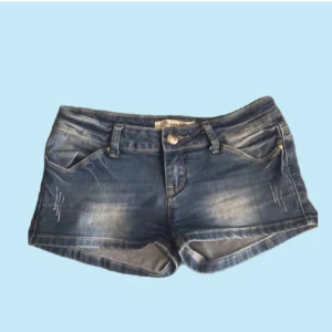 Lågmidjade jeansshorts - Snygga blå jeansshorts från fionina med låg midja och slitna detaljer framtill. Perfekta för varma sommardagar och enkel att matcha med allt. Passar xs-s. Köpta för 350, kan gärna gå ner i priset.⚠️ BARA POSTNORD