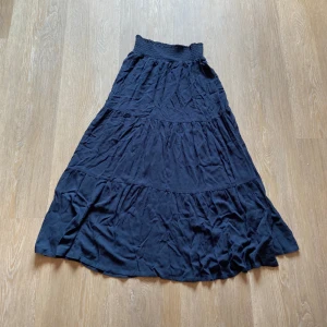 Mörkblå långkjol Bella XS - Säljer en mörkblå långkjol från lager 157 i storlek XS. Kjolen har en smockad midja och flera volanger. Jag gick in och kollade på lager 157 och det verkar som att kjolen inte finns kvar i mörkblått där. Jag säljer den för 100kr men nypris är 200kr.