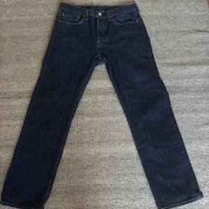Levi's 501 mörkblå jeans W32 L30 - Säljer ett par klassiska Levi's 501 jeans i mörkblå tvätt med raka ben och fem fickor. Nästan oanvända. Säljer då de är i fel storlek. Hör av dig vid frågor och funderingar!