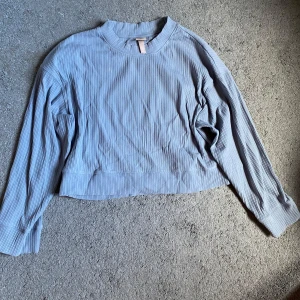 Blå ribbad långärmad tröja H&M - Blå långärmad tröja från H&M i storlek XS. Tröjan har ribbad struktur. Lite mer som sportmaterial. 