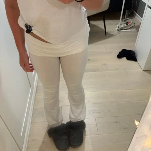 Vita yoga pants från Gina Tricot - Säljer ett par vita yoga pants från Gina Tricot med bootcut-snitt och valfri midja. De är stretchiga och sitter tajt upptill men släpper ut vid anklarna. Perfekta för dig som gillar en clean och enkel look. Materialet är mjukt och bekvämt, passar till många outfits.