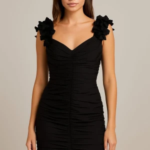 Svart silkesklänning från Silk Studio - Supersnygg svart kortklänning i 100% silke från Silk Studio. Klänningen har v-ringning, rynkade detaljer och axelband med stora blommiga volanger som ger en unik look. Perfekt för dig som vill sticka ut med en elegant och cool stil.